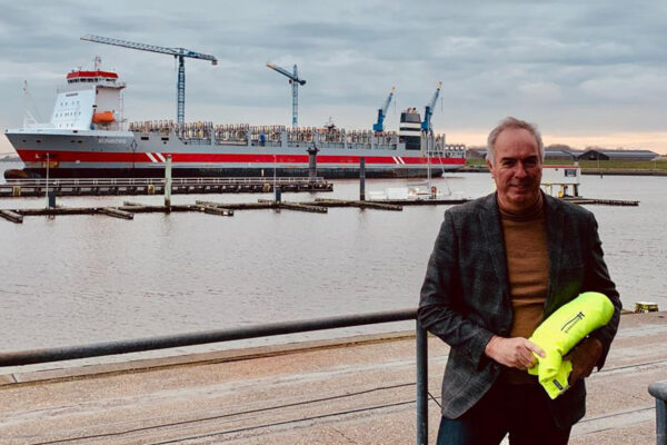 Ton Veraart aan de kade met vrachtschip Rijnborg op de achtergrond, december 2019