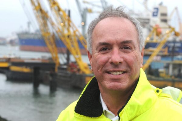 Ton Veraart in geel werkjack voor de havenkranen en schepen
