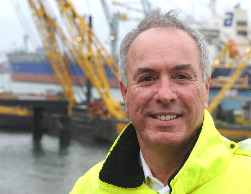 Ton Veraart in geel werkjack voor de havenkranen en schepen