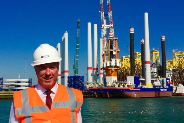 Ton Veraart met helm en veiligheidsvest voor offshore-installatieschip Van Oord met windturbineonderdelen